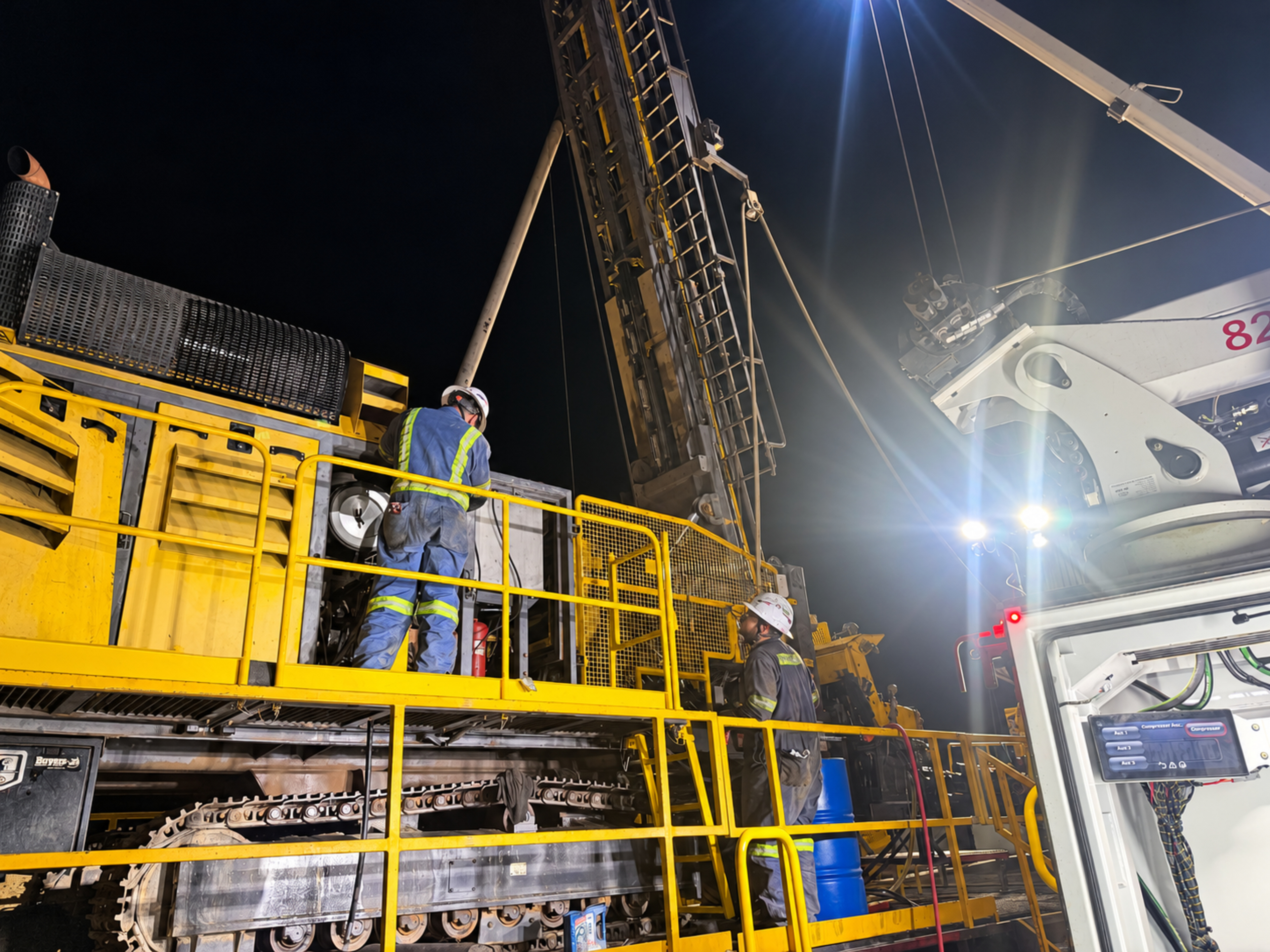 Drill rig maintenance under work lights at night